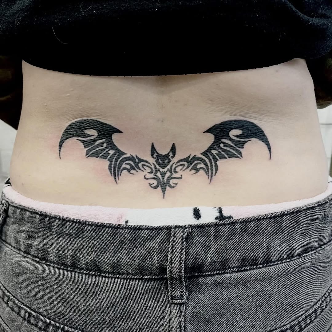 Tatuagem de morcego em preto na zona lombar