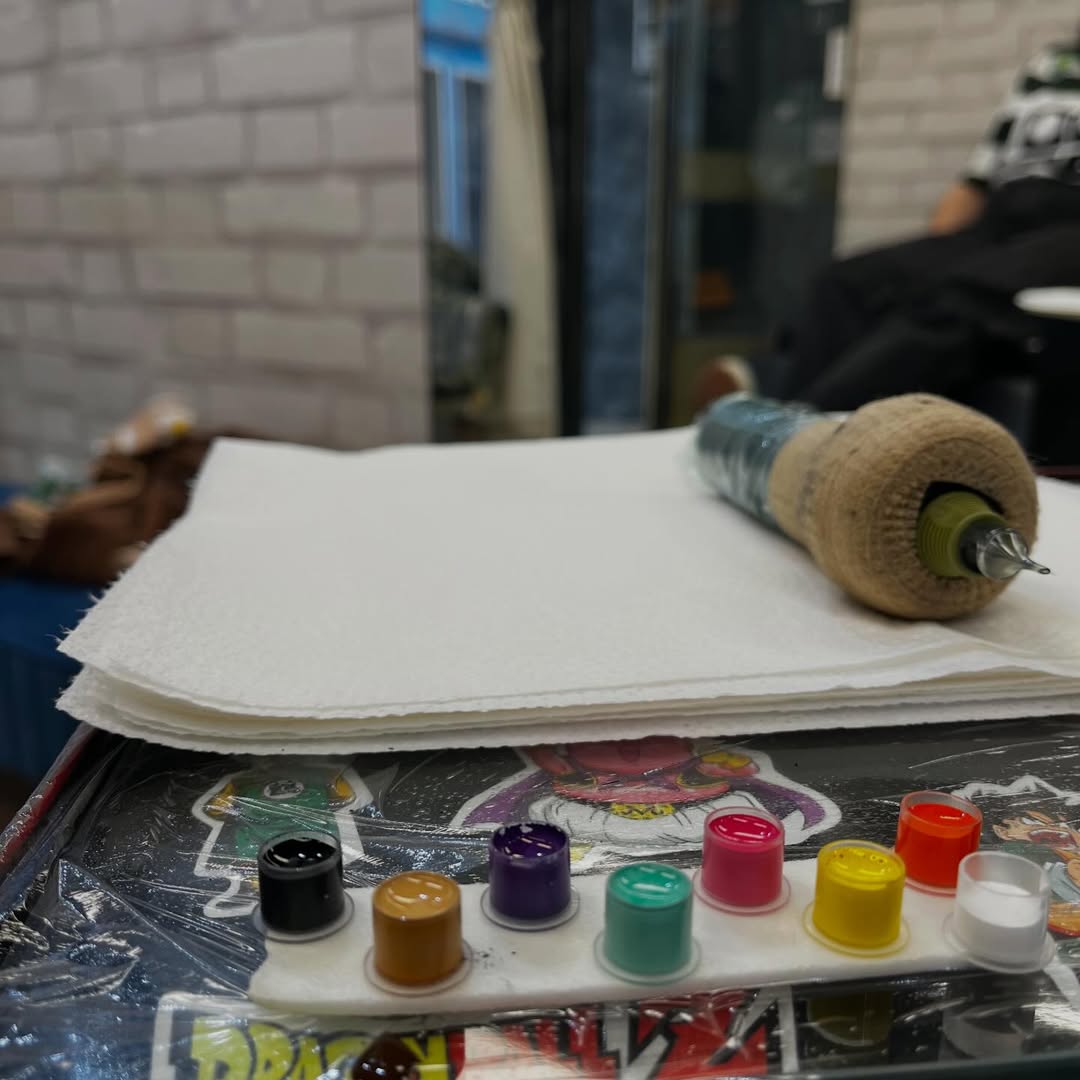 Mesa de trabalho do estúdio com tintas e material de tatuagem